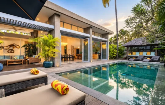 view of luxurious villa exterior from the swimming pool area at dusk