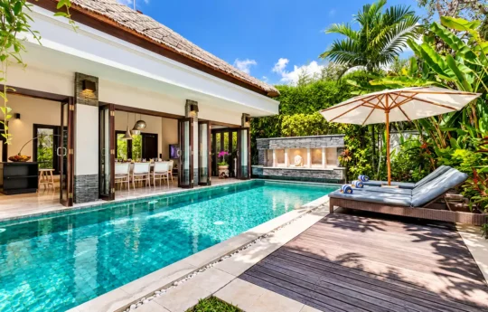 Sunbeds by the pool during daytime with Villa Jepun's interiors in background